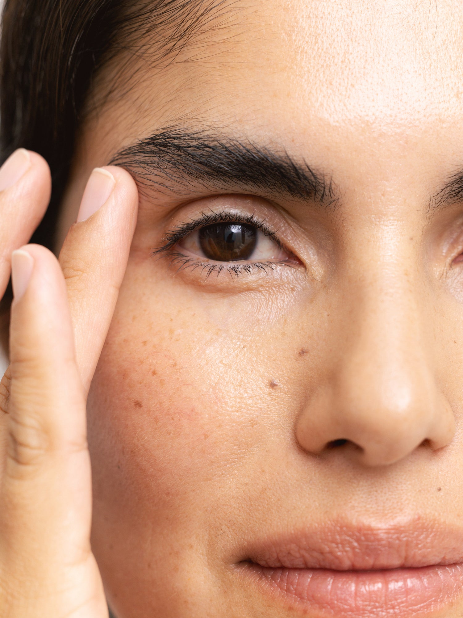 Woman applying Reflekt 4 Smoothing Squalane Eye & Lip Treatment Cream to under-eye and lip areas, demonstrating targeted hydration