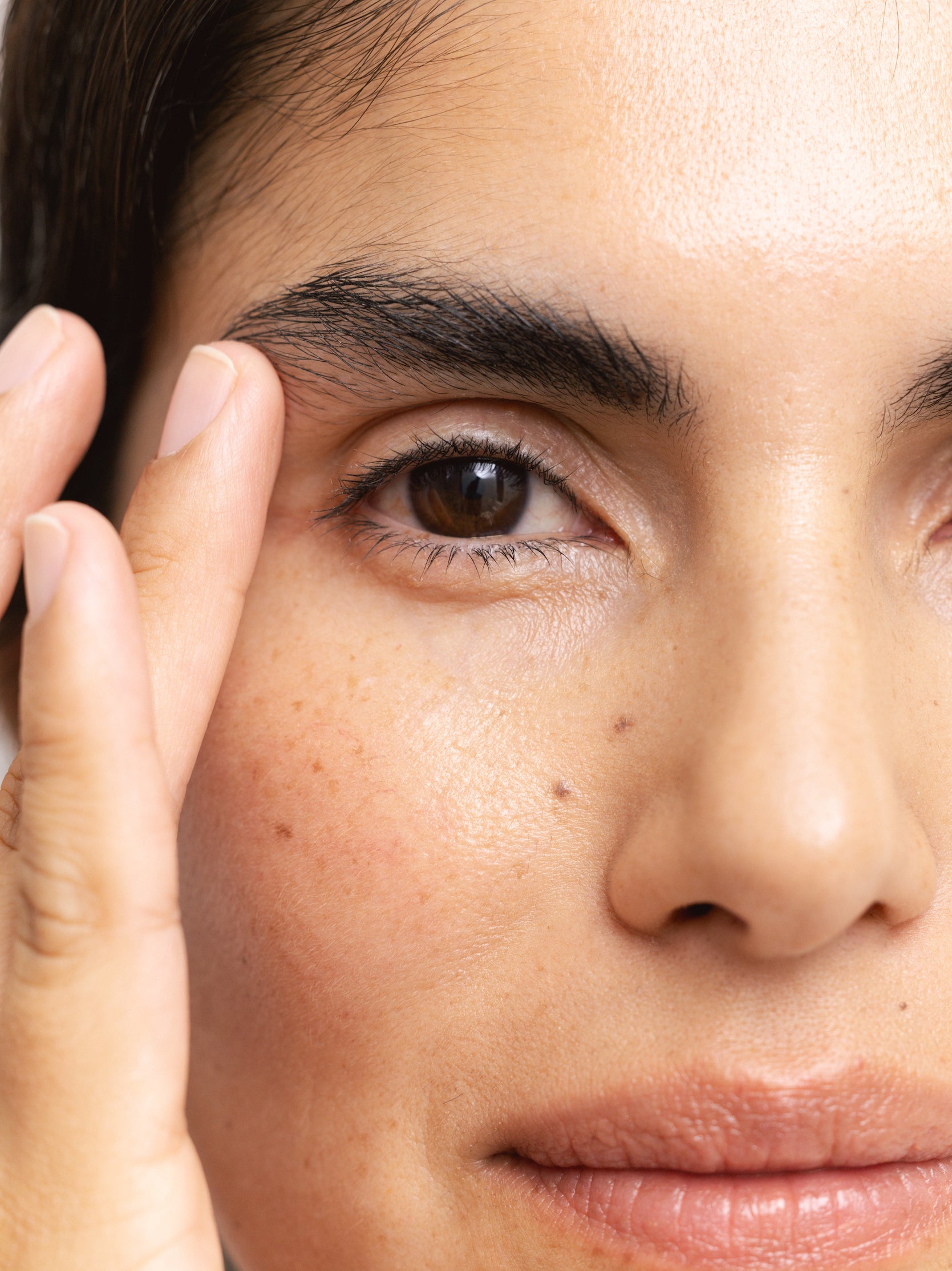 Woman applying Reflekt 4 Smoothing Squalane Eye & Lip Treatment Cream to under-eye and lip areas, demonstrating targeted hydration