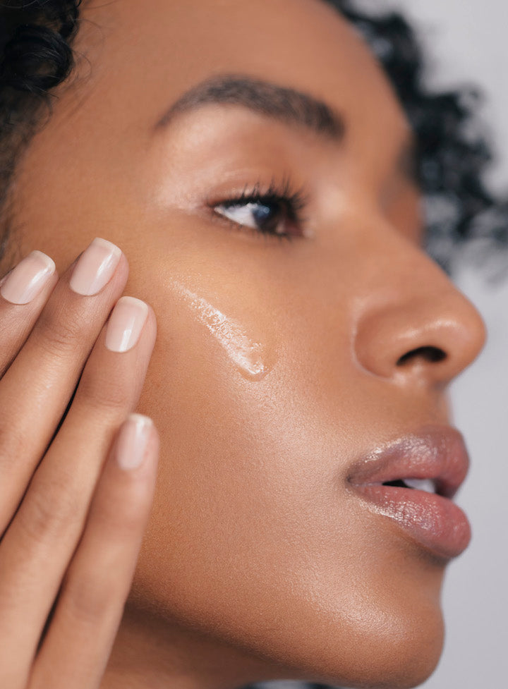 Woman applying Reflekt 2 to dry skin, showcasing silky hydration